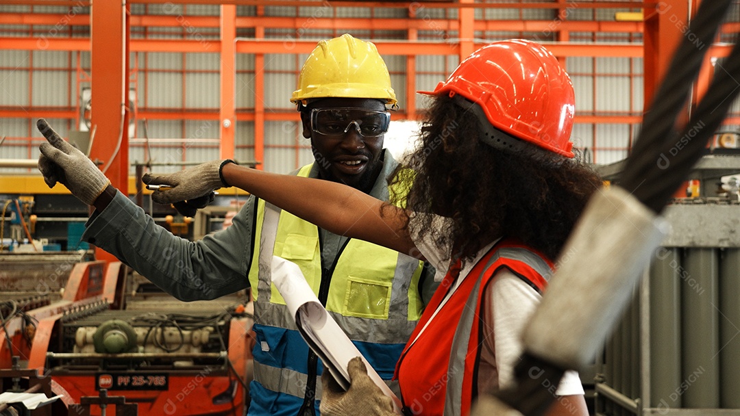 Engenheiros industriais pesados ​​estão juntos em uma fábrica de aço.