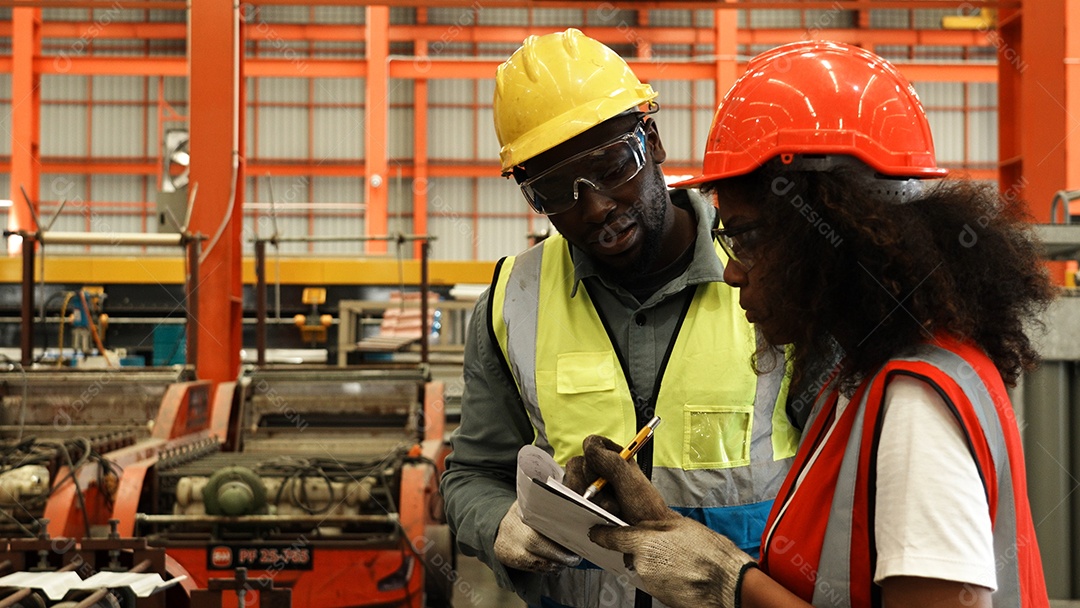 Engenheiros industriais pesados ​​estão juntos em uma fábrica de aço.