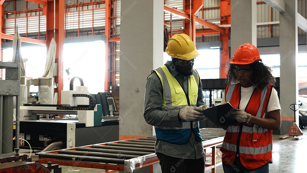Engenheiros industriais pesados ​​estão juntos em uma fábrica de aço.