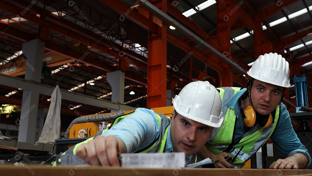 Engenheiros industriais pesados ​​verificam juntos em uma fábrica de aço.