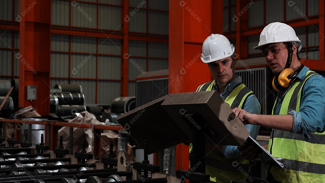 Engenheiros industriais pesados ​​verificam juntos em uma fábrica de aço.