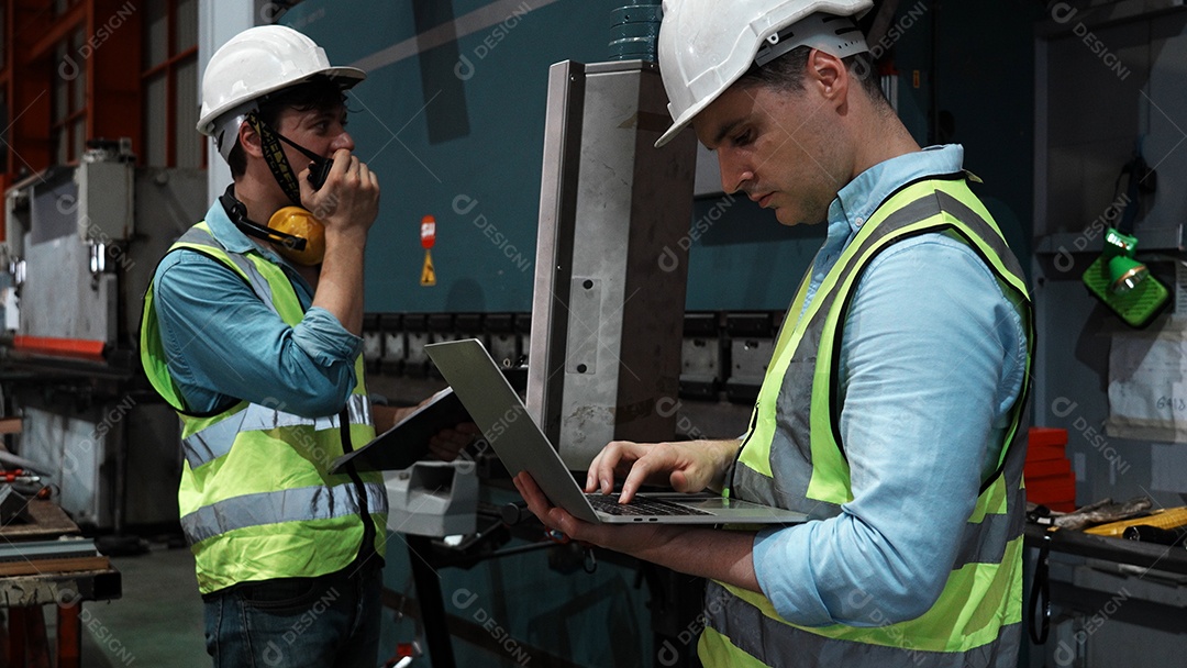 Engenheiros industriais pesados ​​verificam juntos em uma fábrica de aço.
