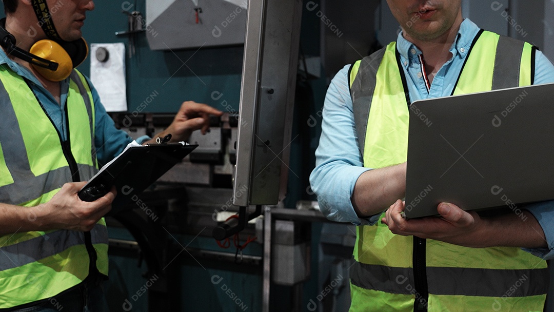 Engenheiros industriais pesados ​​verificam juntos em uma fábrica de aço.