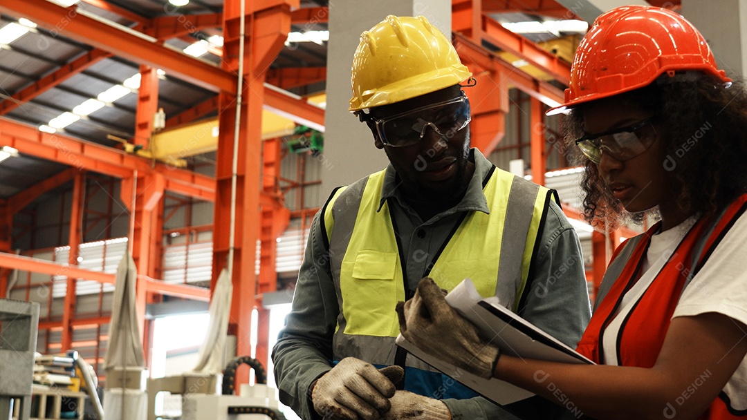 Engenheiros industriais pesados ​​verificam juntos em uma fábrica de aço.