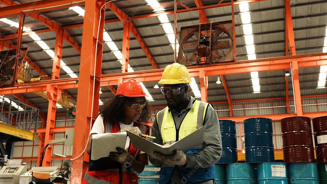 Engenheiros industriais pesados ​​verificam juntos em uma fábrica de aço.