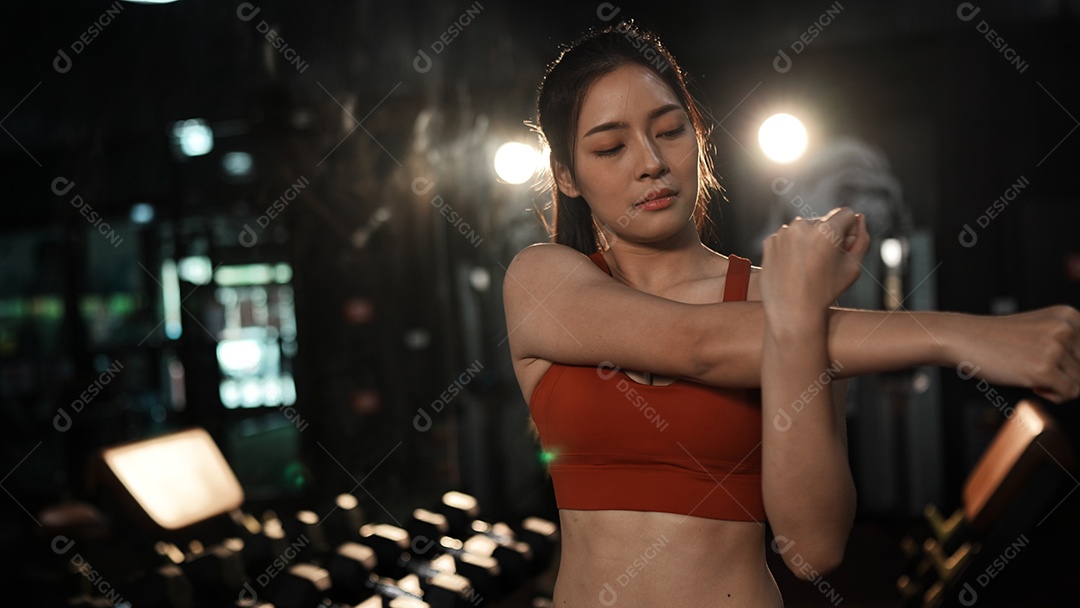 Mulher asiática desportiva atrativa que estica o treino