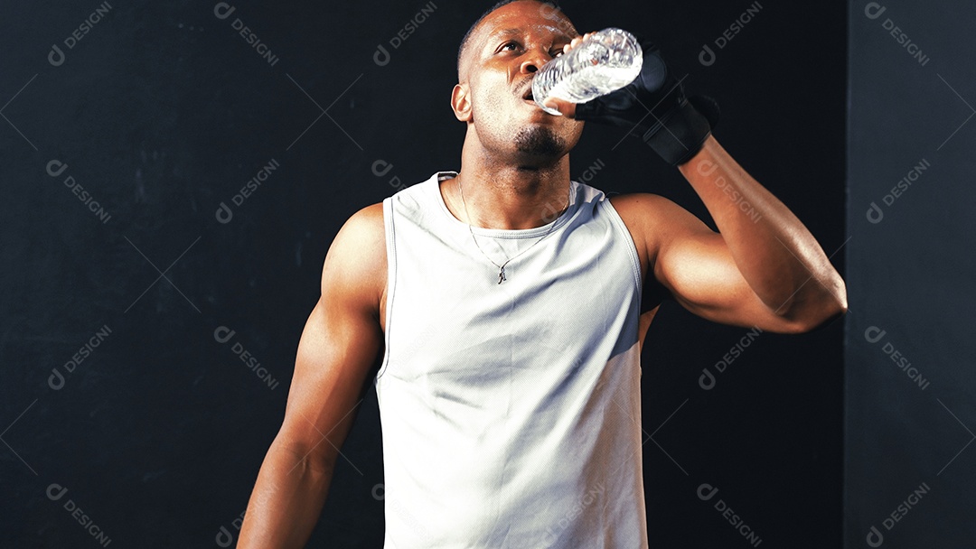 Água potável do esportista afro-americano após treinamento crossfit na academia
