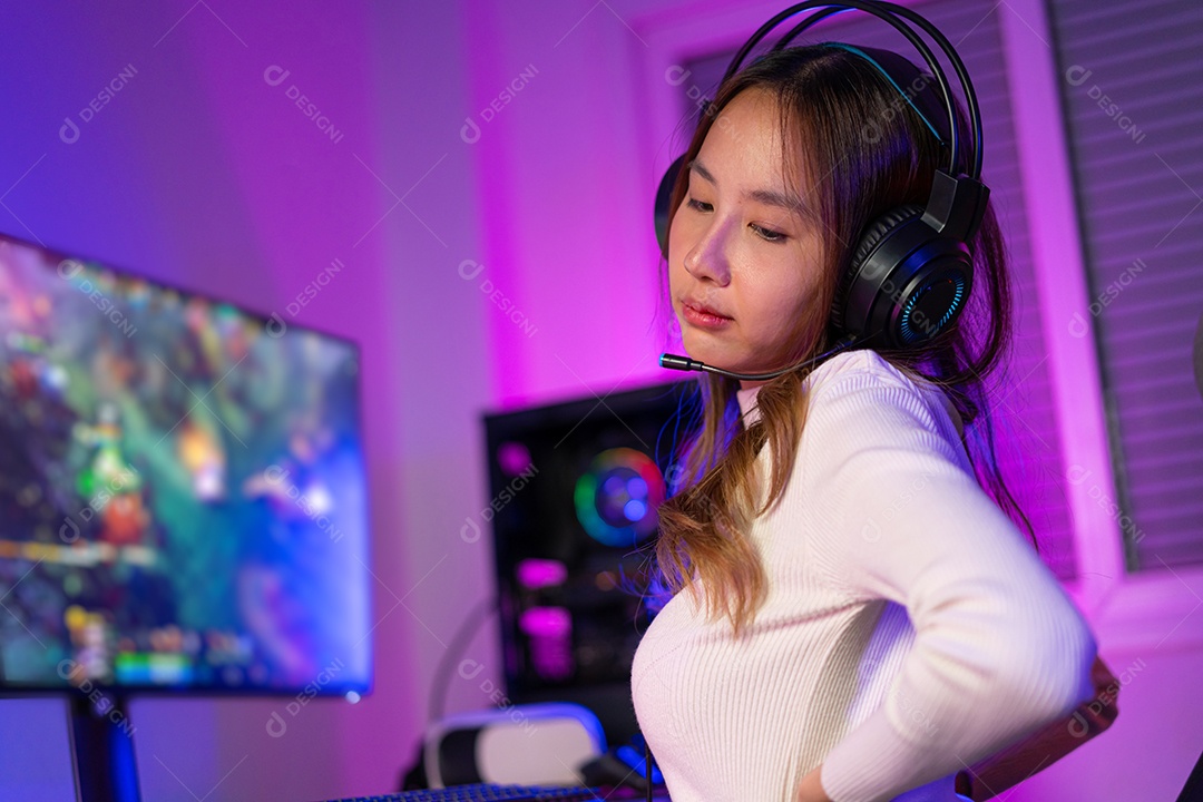 Jogador e E-Sport online de mulher asiática jogando videogame ela está com dor nas costas por ficar muito tempo sentada