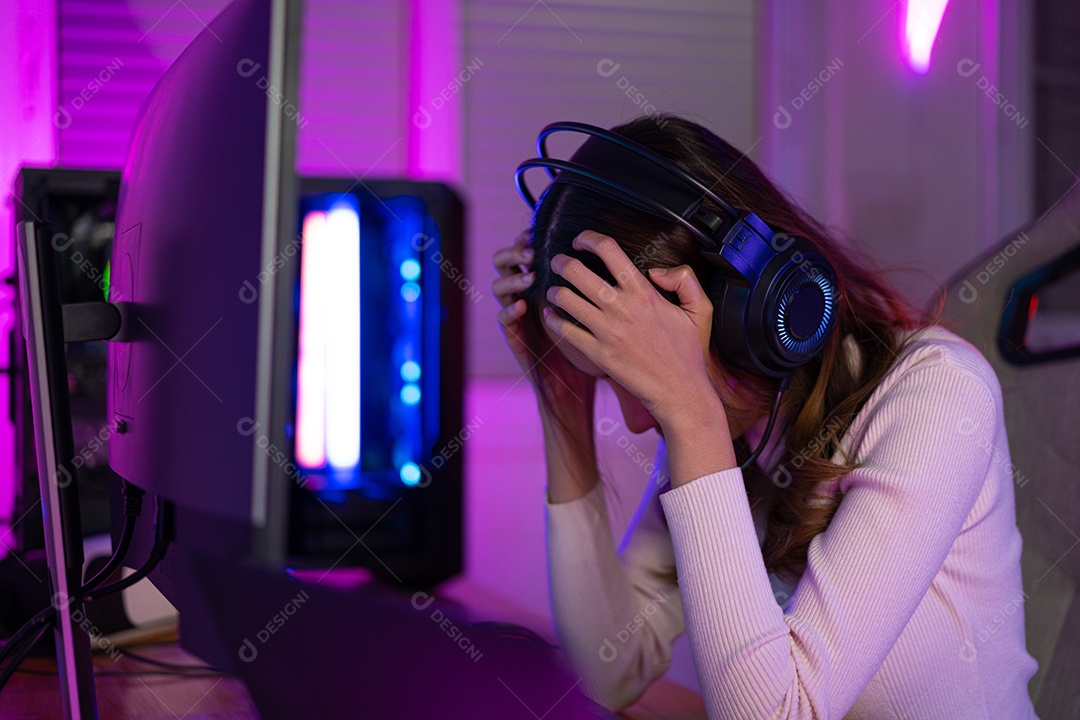 Partida de perda de jogo. Jogo asiático com fones de ouvido jogando videogame online no computador PC luz neon em casa sentindo-se triste e desapontado com a perda do jogo