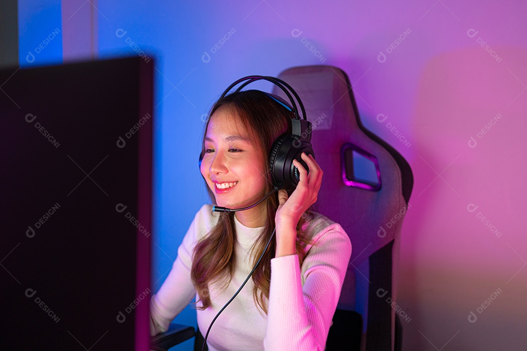 Jogador e E-Sport online de mulher asiática jogando videogame de computador online com efeito de iluminação, transmissão ao vivo em casa.