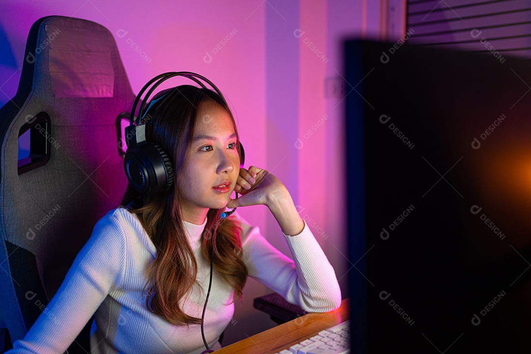 Jogador e E-Sport online de mulher asiática jogando videogame de computador online com efeito de iluminação, transmissão ao vivo em casa.