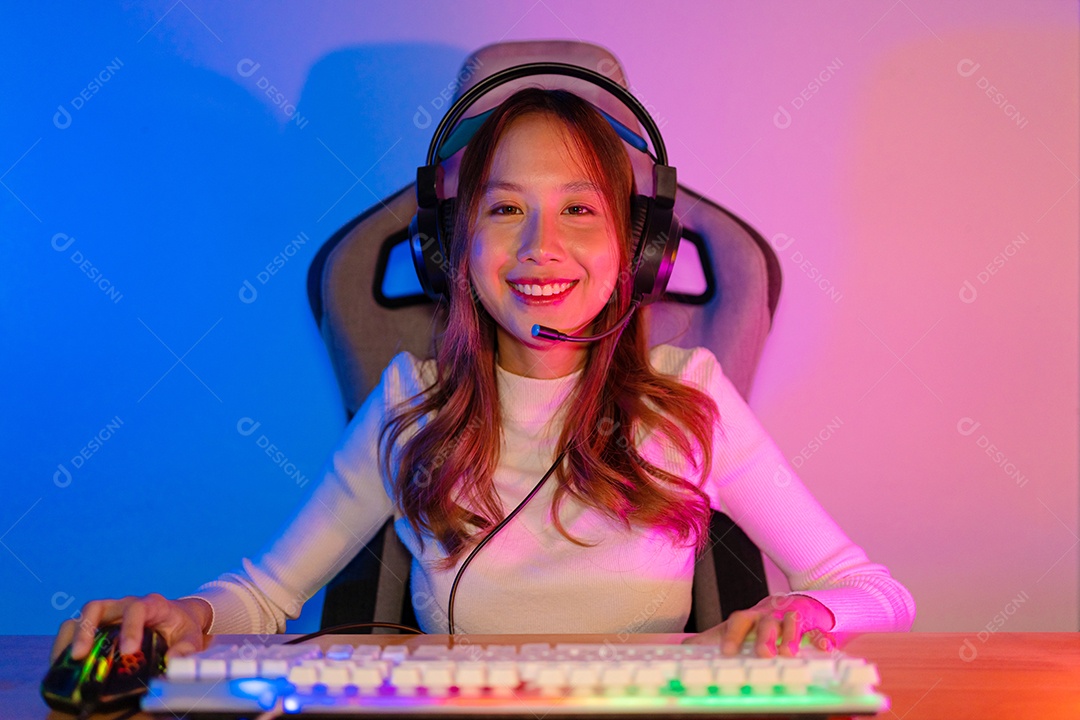 Jogador e E-Sport online de mulher asiática jogando videogame de computador online com efeito de iluminação, transmissão ao vivo em casa.