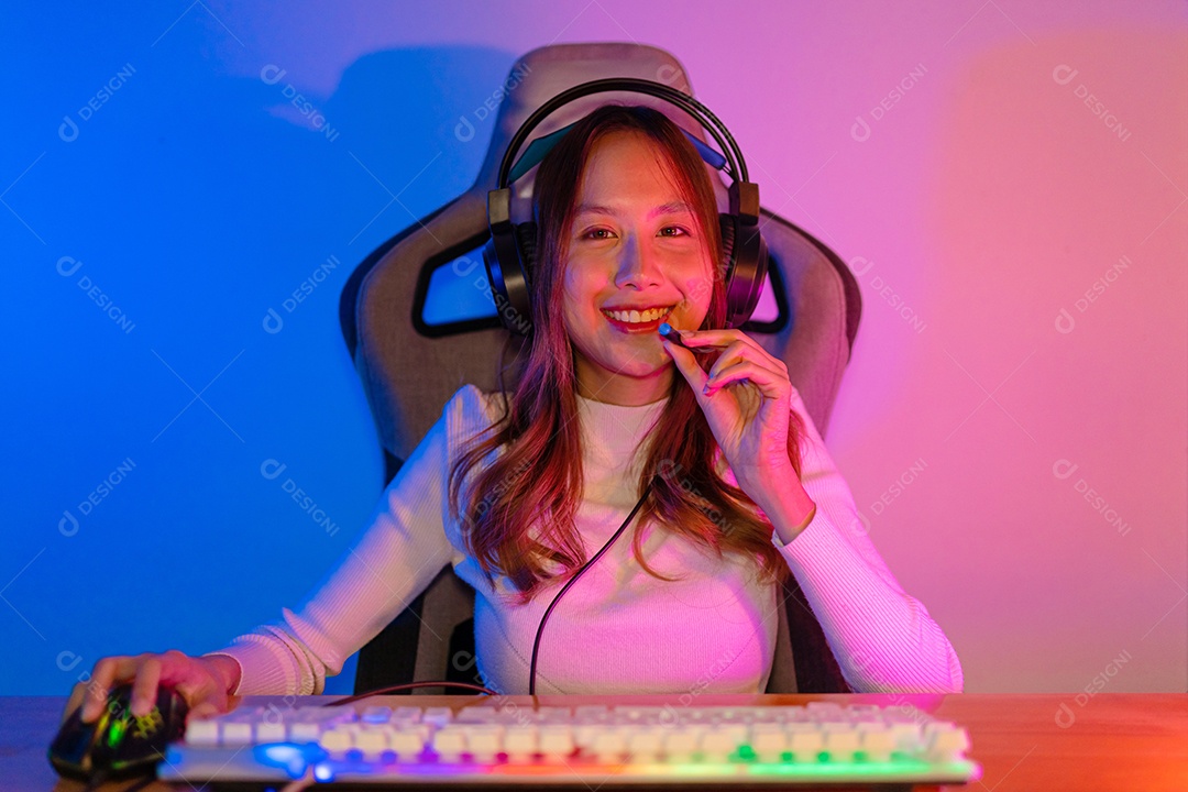 Jogador e E-Sport online de mulher asiática jogando videogame de computador online com efeito de iluminação, transmissão ao vivo em casa.