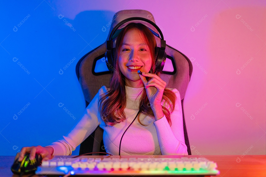 Jogador e E-Sport online de mulher asiática jogando videogame de computador online com efeito de iluminação, transmissão ao vivo em casa.