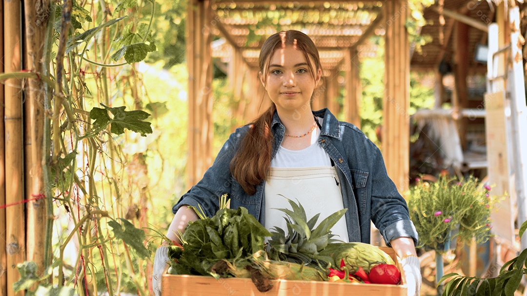 Mulher jovem agricultora colhendo vegetais na fazenda
