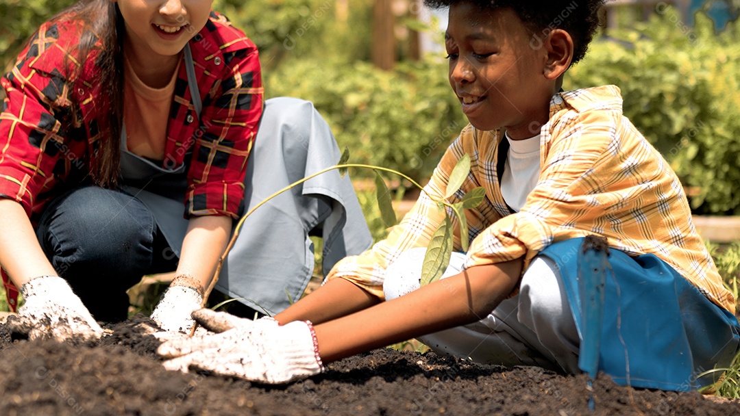 Criança bonita plantando árvore jovem no solo preto trabalhando no jardim como salvar o conceito de mundo