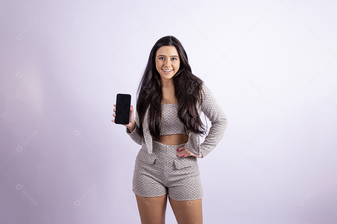 Linda mulher jovem segurando celular smartphone sobre fundo isolado branco
