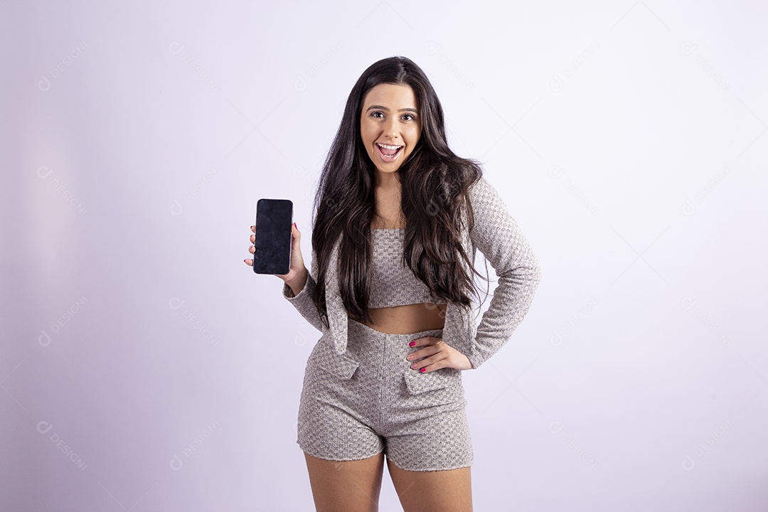 Linda mulher jovem segurando celular smartphone sobre fundo isolado branco