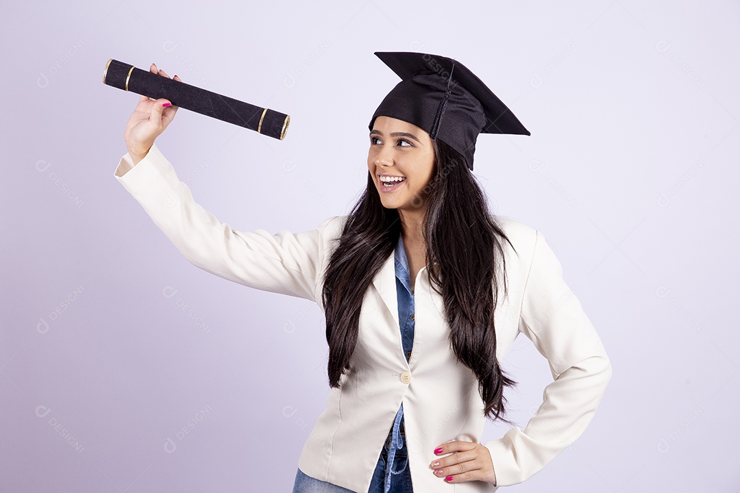 Linda mulher jovem usando capelo e segurando canudo de formatura sobre fundo isolado branco