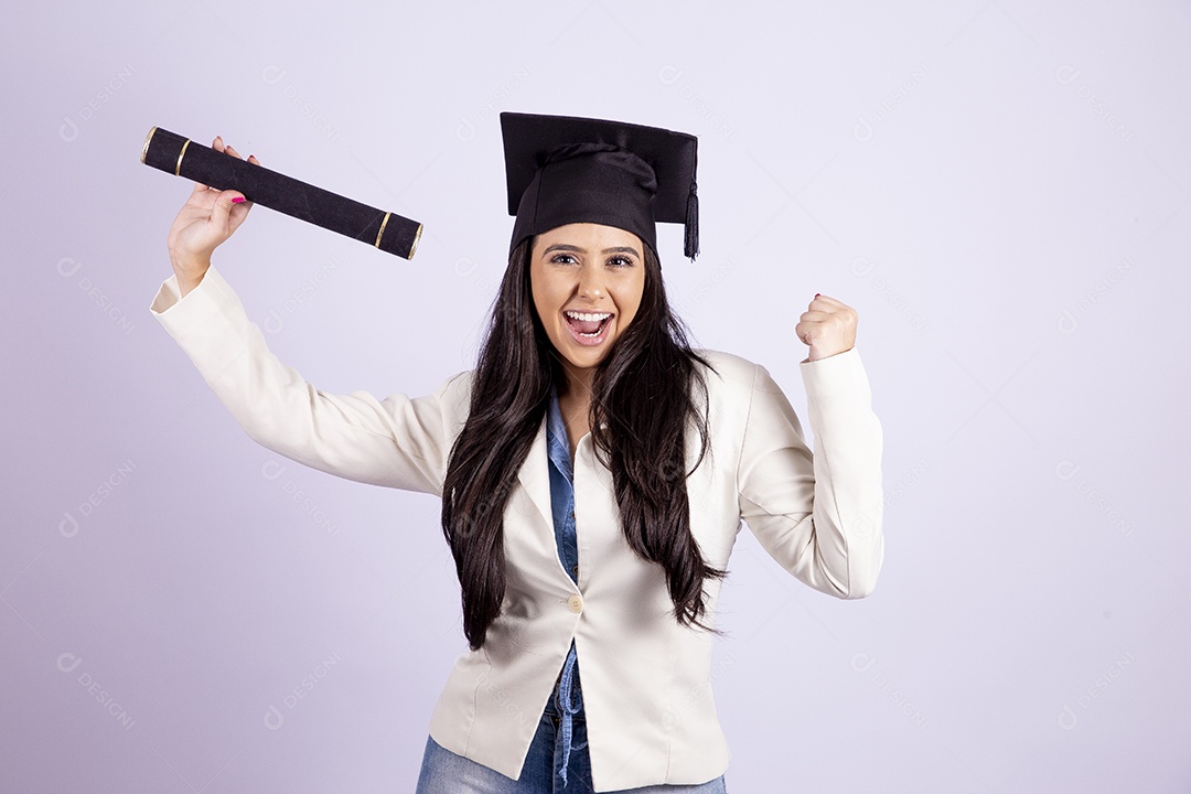 Linda mulher jovem usando capelo e segurando canudo de formatura sobre fundo isolado branco