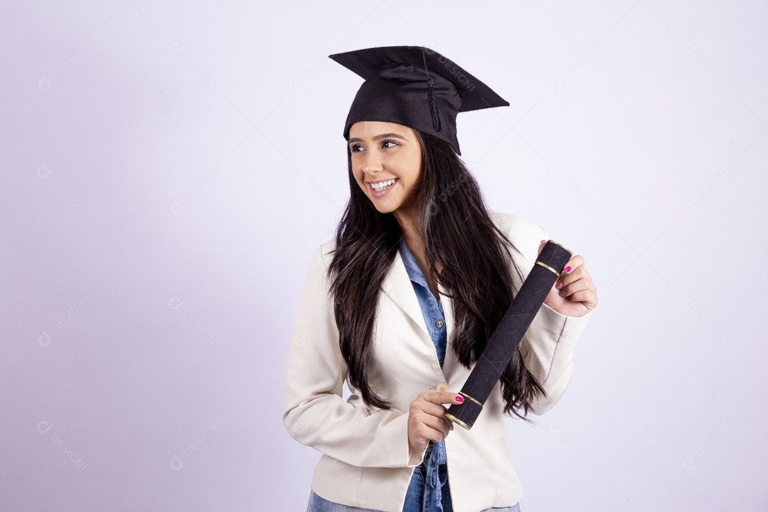 Linda mulher jovem usando capelo e segurando canudo de formatura sobre fundo isolado branco