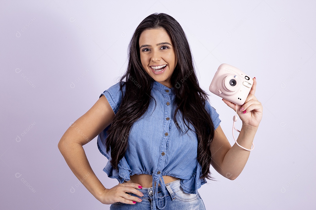 Linda mulher jovem segurando câmera fotográfica sobre fundo isolado branco