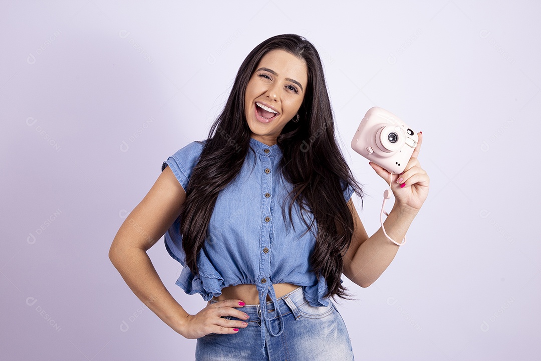 Linda mulher jovem segurando câmera fotográfica sobre fundo isolado branco