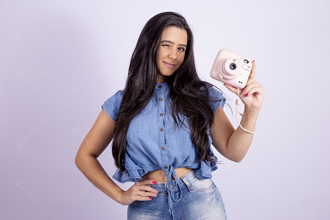 Linda mulher jovem segurando câmera fotográfica sobre fundo isolado branco