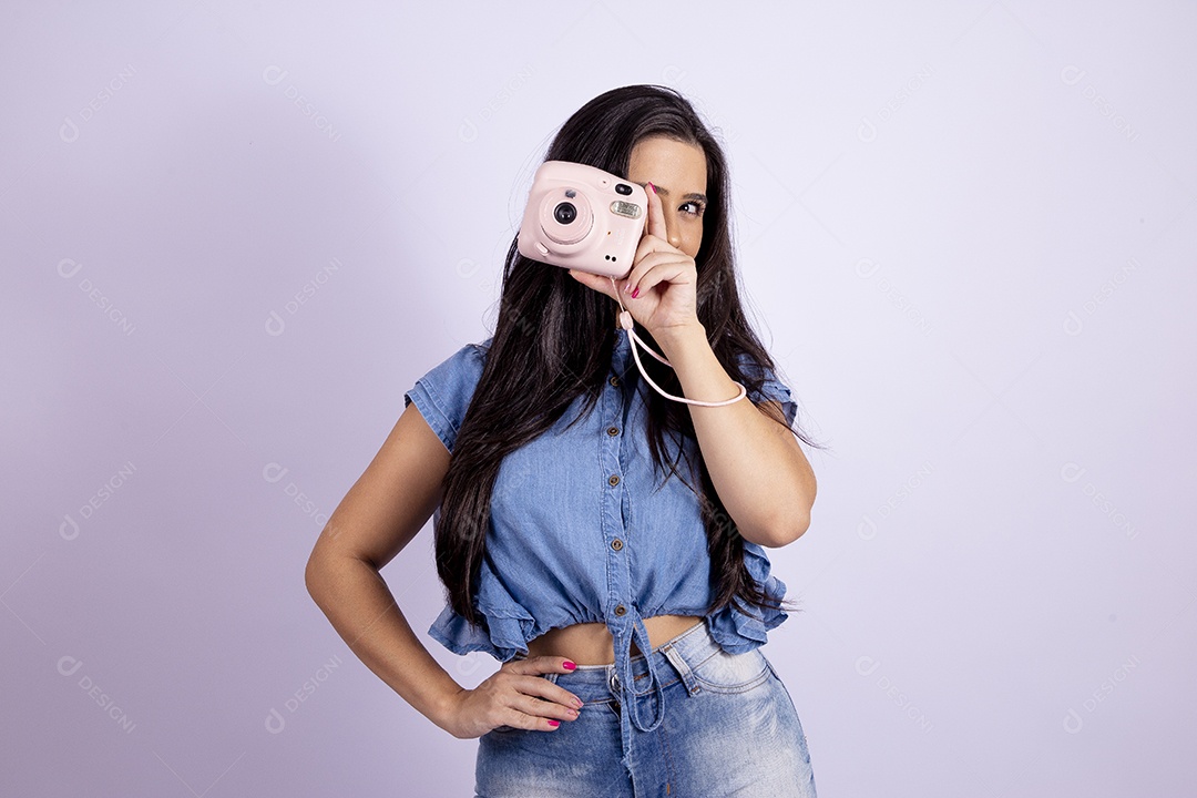 Linda mulher jovem segurando câmera fotográfica sobre fundo isolado branco