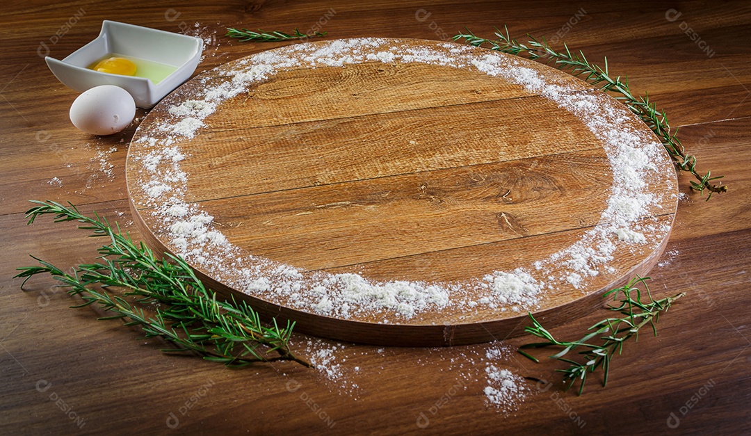 Forma de pizza de madeira, embrulhada em trigo, ovos e alecrim.