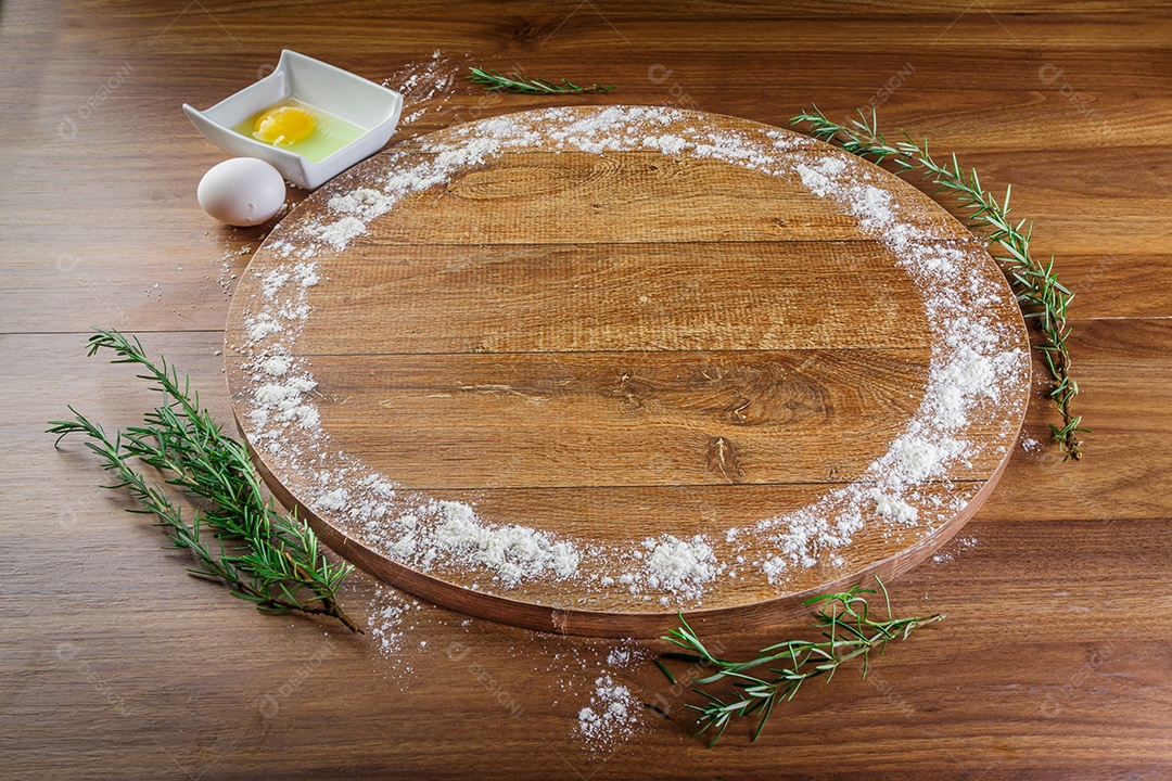 Forma de pizza de madeira, embrulhada em trigo, ovos e alecrim.