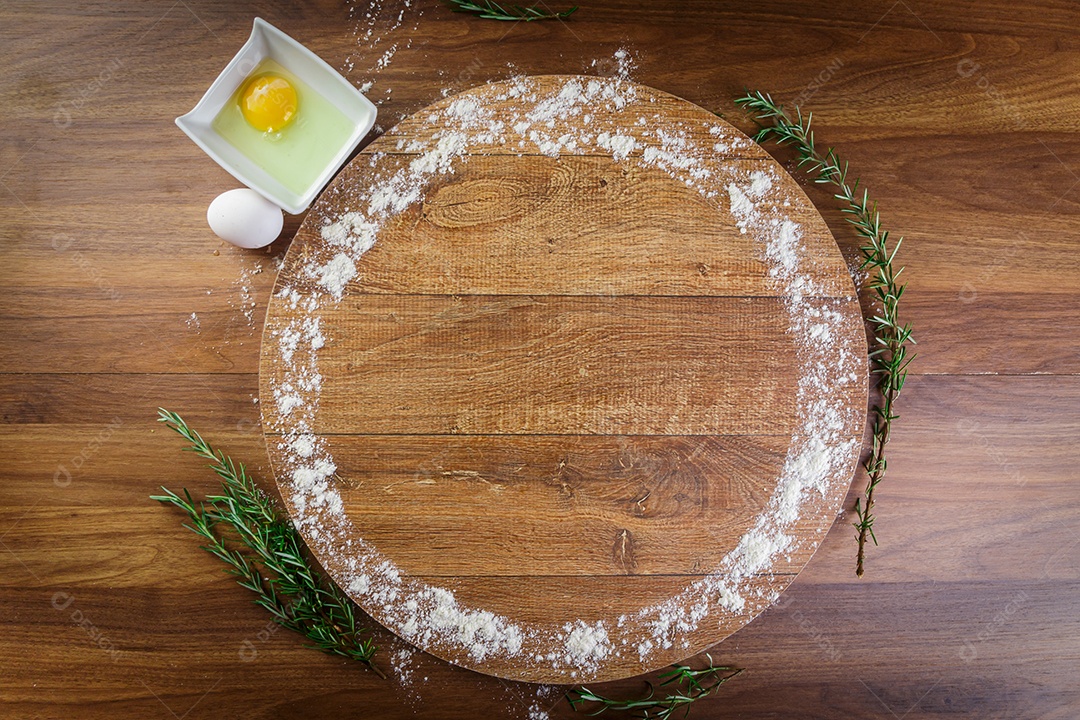 Forma de pizza de madeira, embrulhada em trigo, ovos e alecrim.