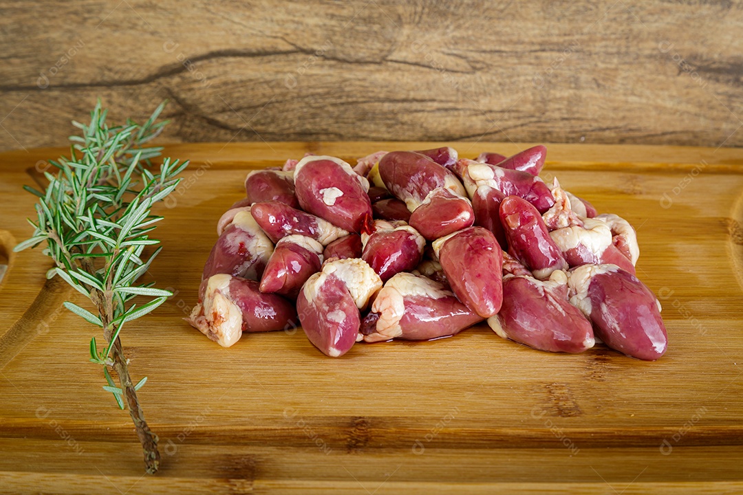 Miudezas de corações de peru cru. Fundo de madeira.