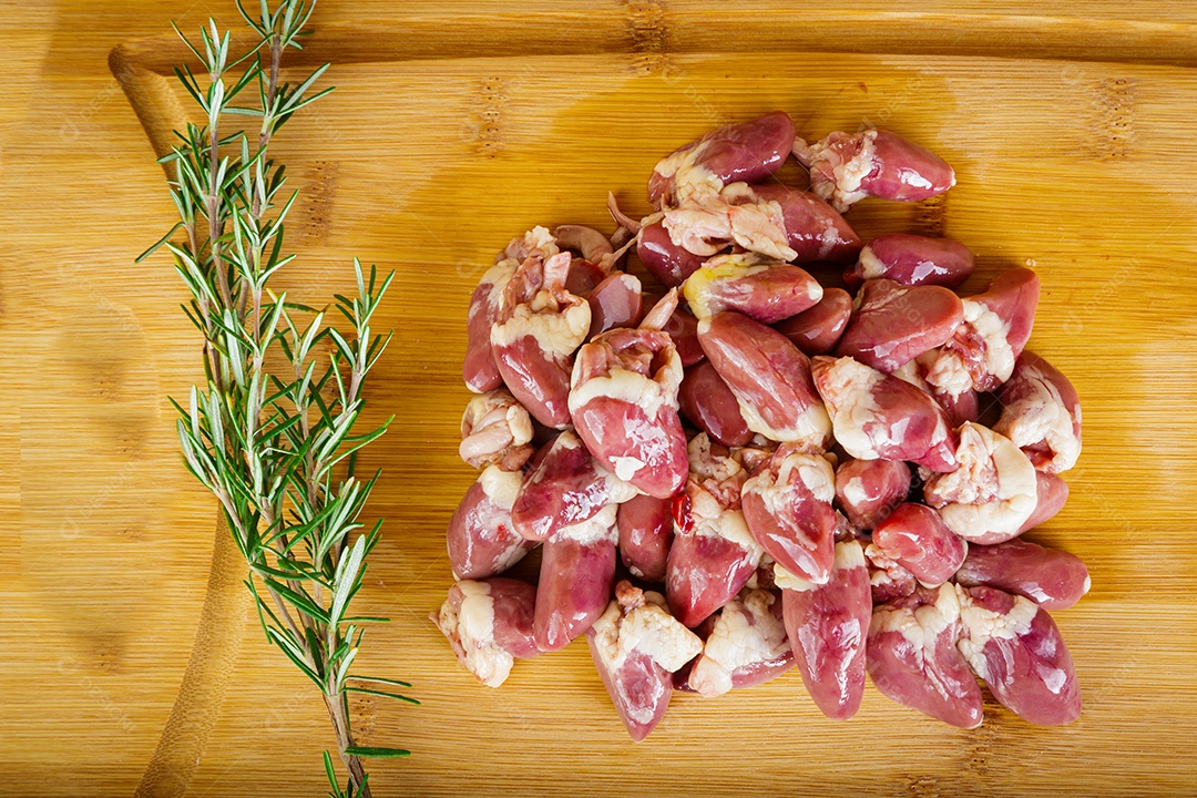 Miudezas de corações de peru cru. Fundo de madeira.