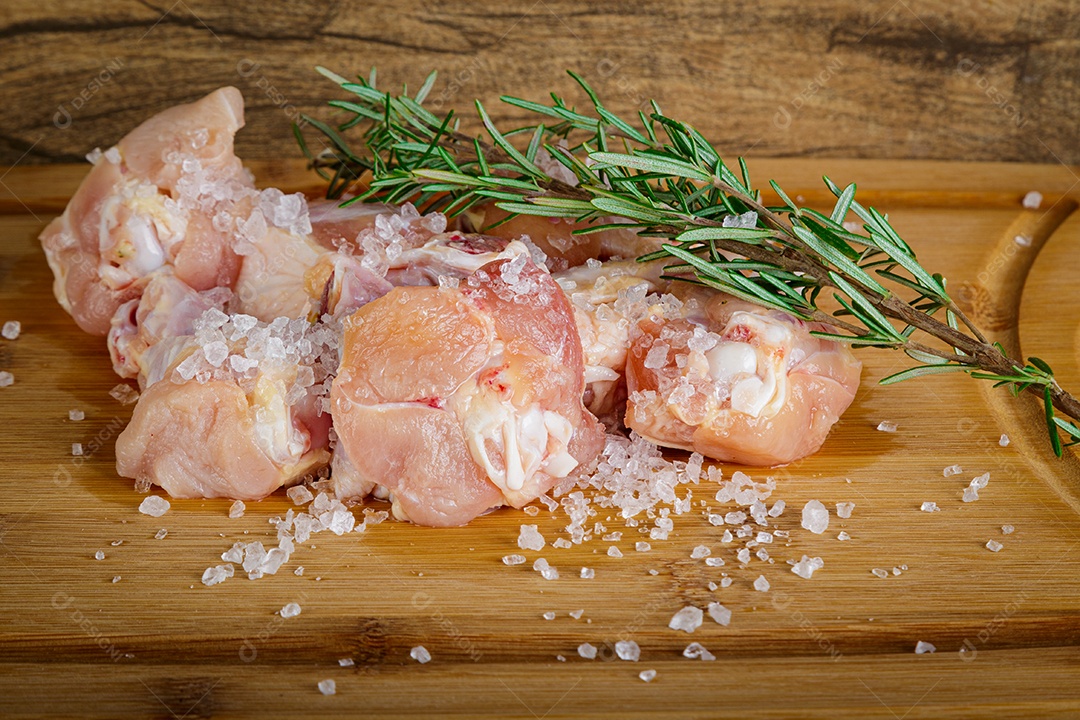 Frango asa de coxa. Fundo de madeira. Vista frontal.