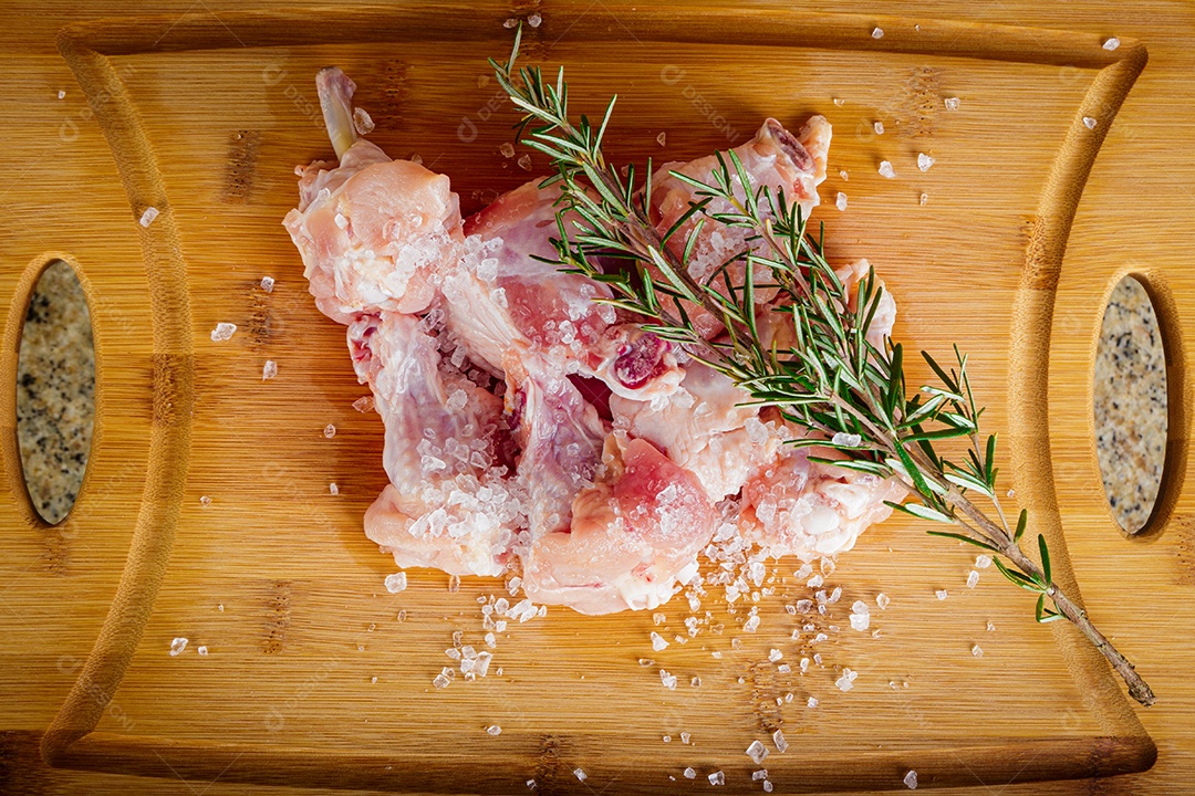 Frango asa de coxa. Fundo de madeira. Vista frontal.