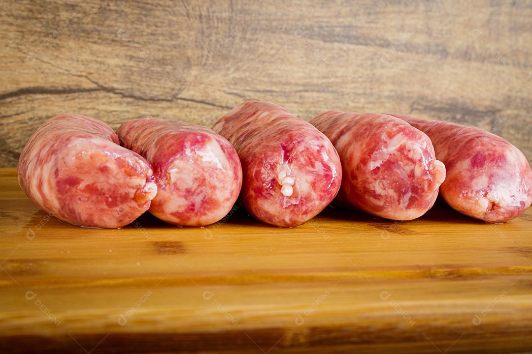 Linguiças cruas na placa de madeira.