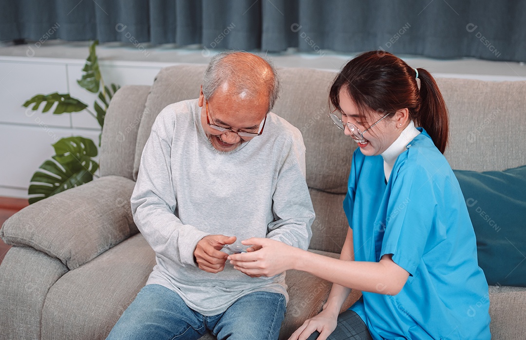 Paciente masculino sênior asiático consulta medicamentos prescritos com enfermeira médica em casa de repouso.