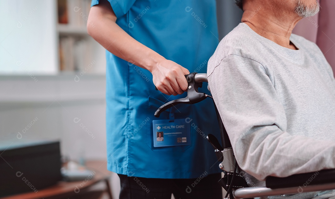 Enfermeira cuidadora asiática apoia idoso sênior em cadeira de rodas na sala de estar.