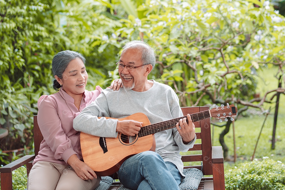 Feliz casal idoso asiático tocando violão se divertindo