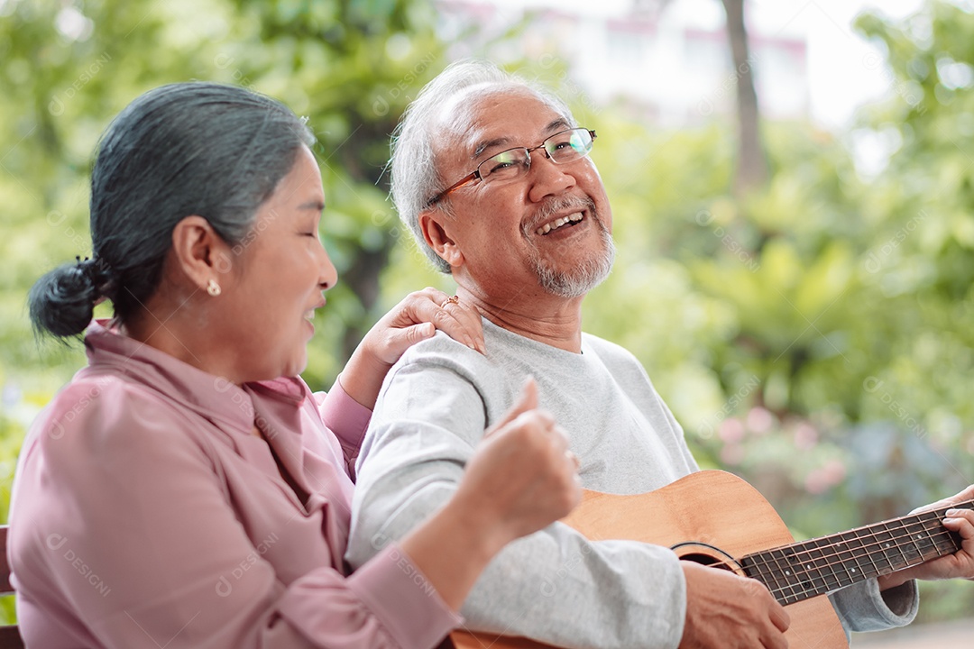 Feliz casal idoso asiático tocando violão