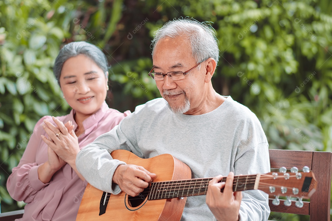Feliz casal idoso asiático tocando violão se divertindo