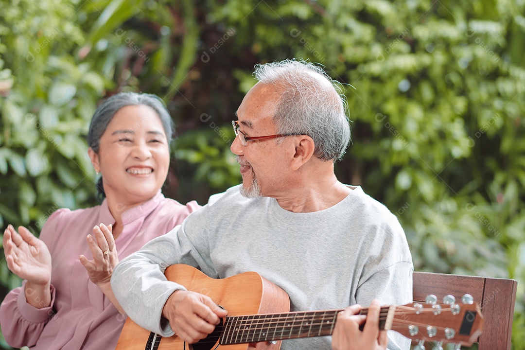 Feliz casal idoso asiático tocando violão se divertindo