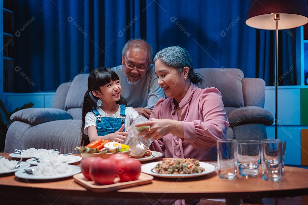 Família feliz asiática comendo na mesa japonesa de jantar sorrindo juntos.