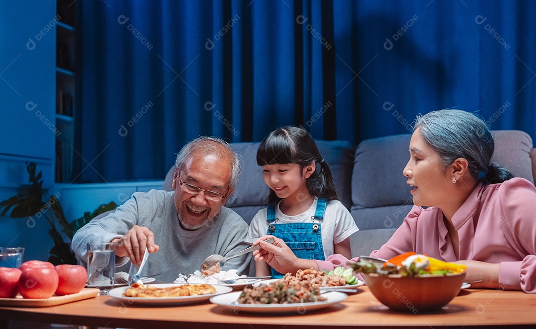 Família feliz asiática comendo na mesa japonesa de jantar sorrindo juntos.