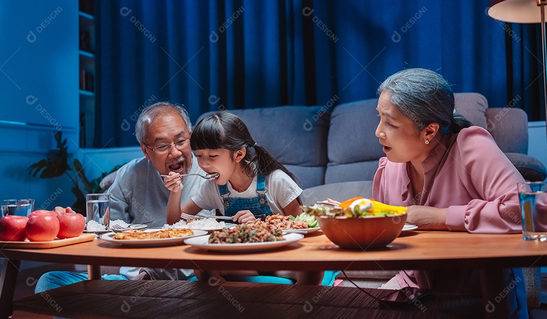 Família feliz asiática comendo na mesa japonesa de jantar sorrindo juntos.
