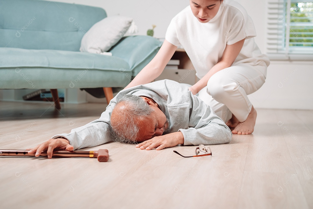 Filha ou neta de mulher asiática ajudando o homem sênior caído no chão