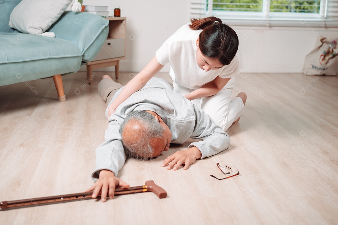 Filha ou neta de mulher asiática ajudando o homem sênior caído no chão