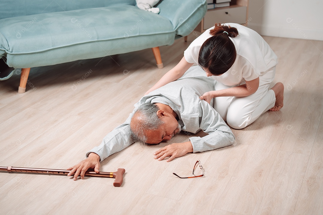 Filha ou neta de mulher asiática ajudando o homem sênior caído no chão