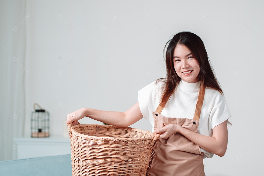 Mulher asiática limpando tarefas domésticas na sala de estar em casa.